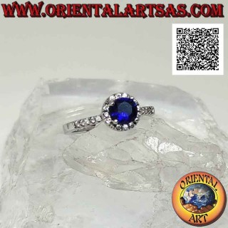 Silver ring with round synthetic sapphire set surrounded by white zircons and on the sides