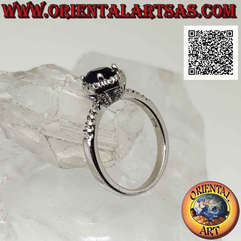 Anello in argento con zaffiro di sintesi tondo incastonato contornato da zirconi bianchi e sui lati