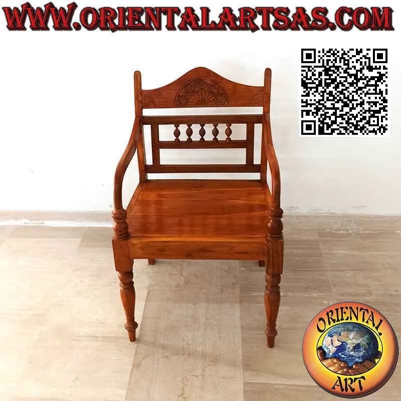 Butaca con rosetón tallado y columnitas sobre respaldo de madera de teca