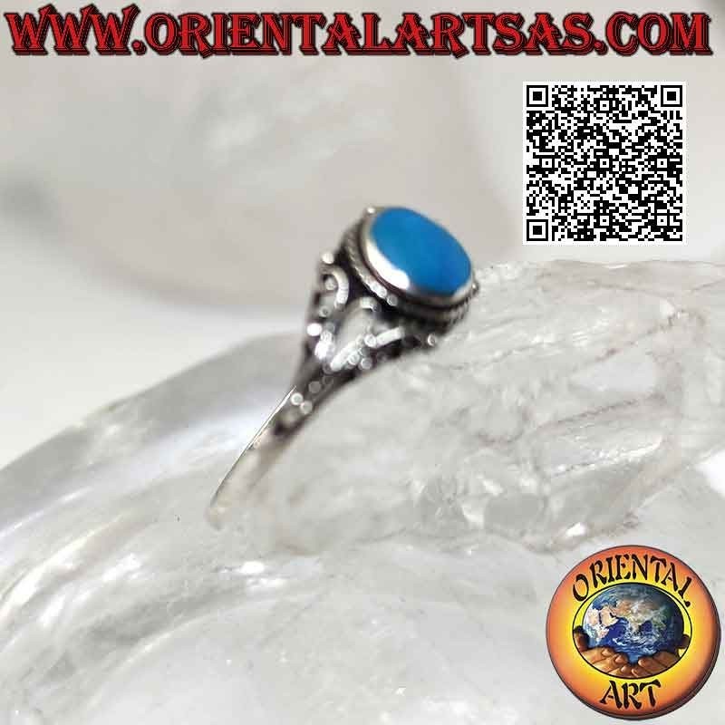 Silver ring with round turquoise surrounded by interweaving and filigree floral decoration on the sides