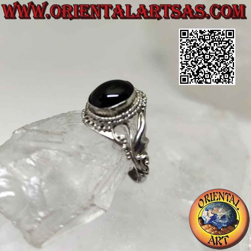 Silver ring with oval cabochon onyx surrounded by balls and threadlike floral decoration on the sides