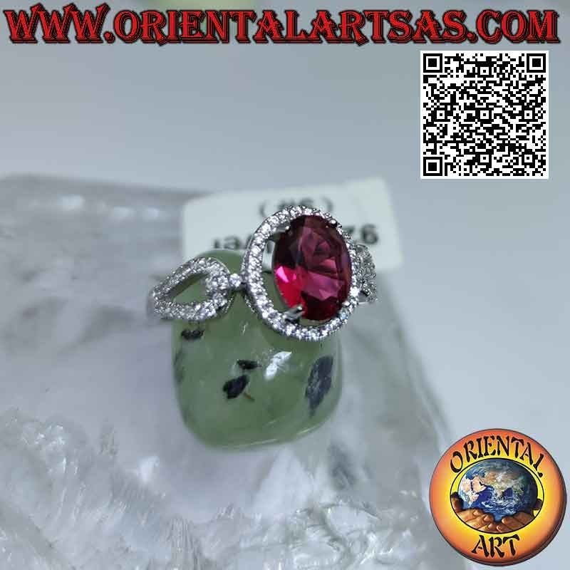 Silver ring with oval garnet set surrounded by white zircons and hooked on the sides