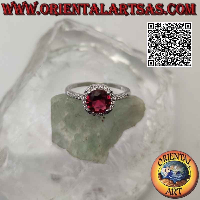 Anillo de plata con rubí sintético redondo engastado rodeado de circonitas y extensión en los laterales