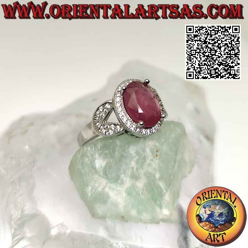 Anillo de plata con gran rubí natural ovalado engastado rodeado de circonitas y enganchado a dos en los laterales