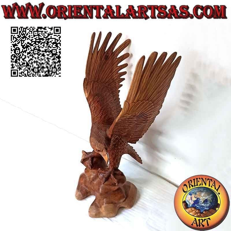 Escultura de águila real con las alas extendidas de pie sobre el promontorio de madera de suar de 80 cm.