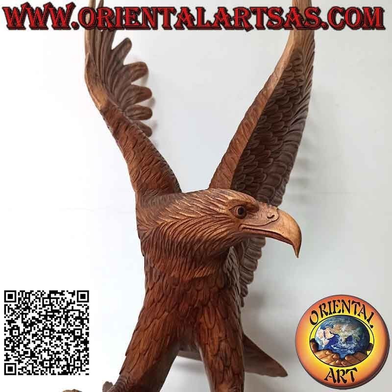 Escultura de águila real con las alas extendidas de pie sobre el promontorio de madera de suar de 80 cm.