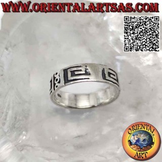 Anillo de banda de plata trabajado con una serie de círculos y espirales cuadradas lisas sobre un fondo liso