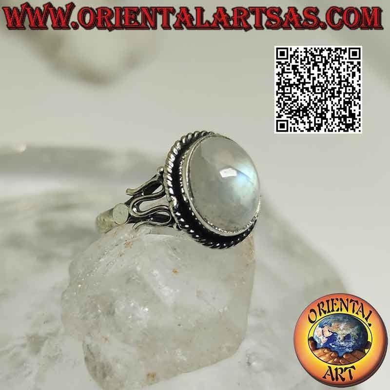Silver ring with cabochon oval rainbow moonstone surrounded by interweaving and serpentine on the sides