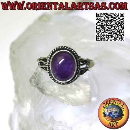 Silver ring with cabochon oval amethyst surrounded by interweaving and serpentine on the sides