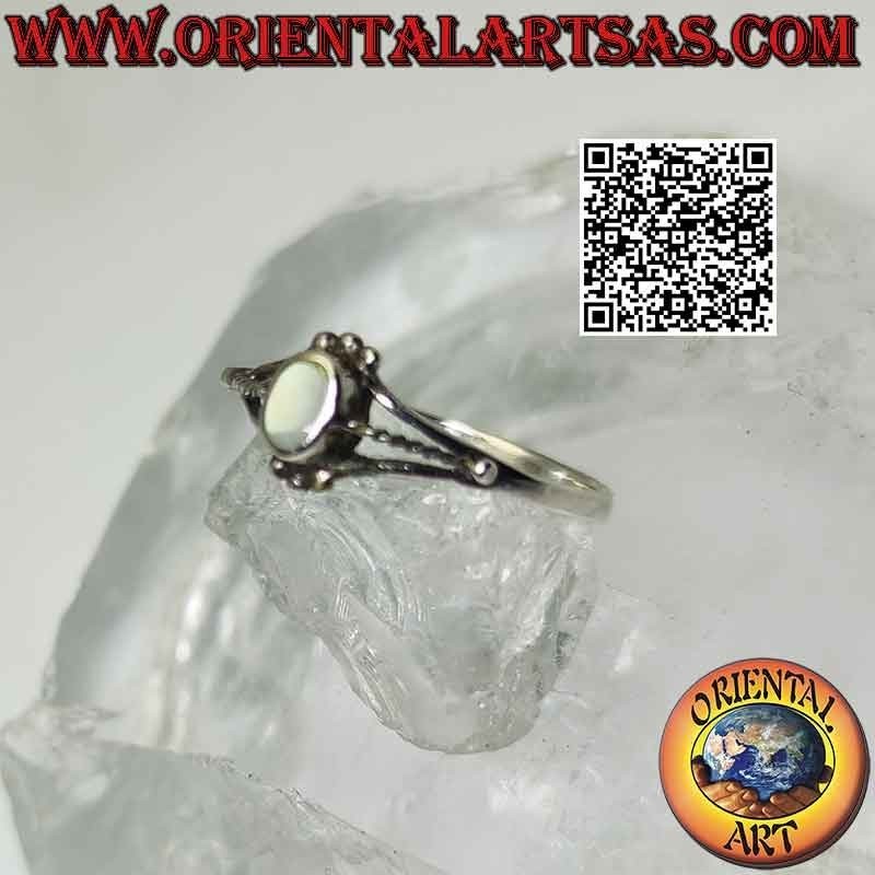 Silver ring with oval mother of pearl between trio of balls