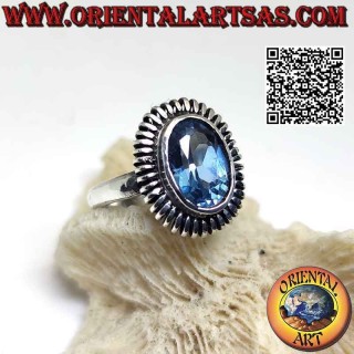 Silver ring with oval blue topaz surrounded by a smooth spring
