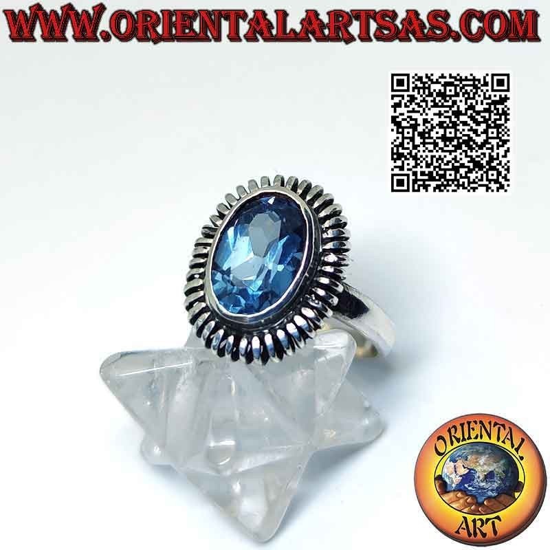 Anillo de plata con topacio azul ovalado rodeado de un resorte liso