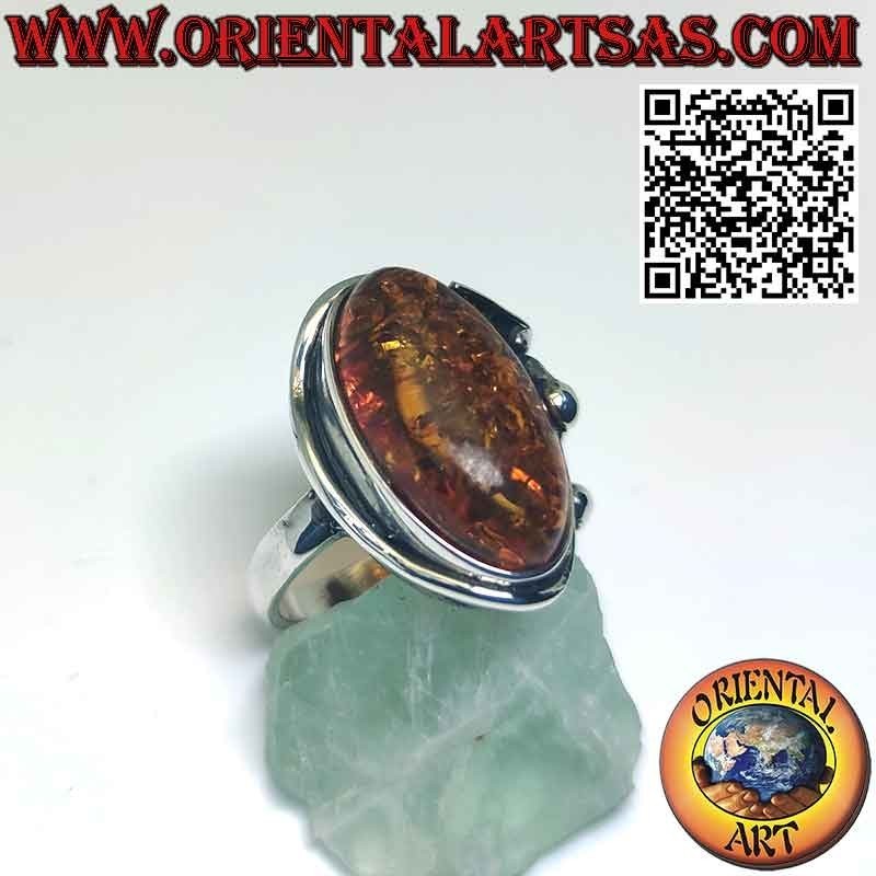 Anillo de plata con gran ámbar ovalado y flor de lirio en un lado
