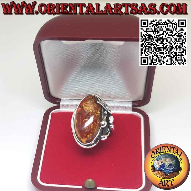Anillo de plata con gran ámbar ovalado y flor de lirio en un lado