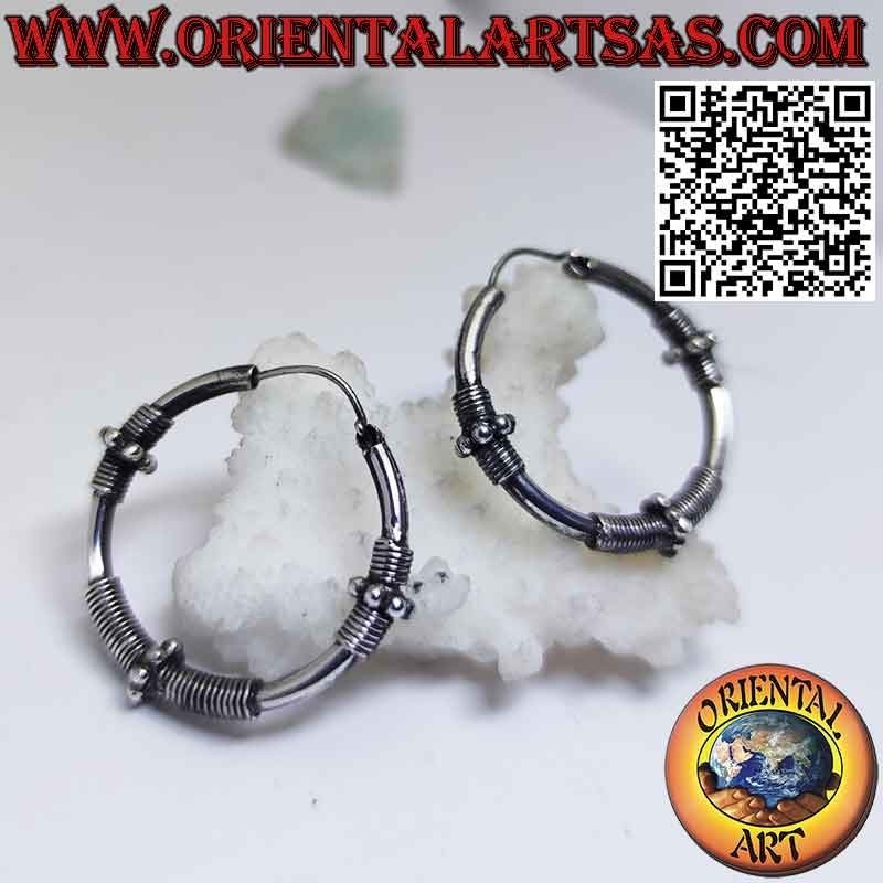 Earrings in silver circle with three sections of coiled wire and spheres