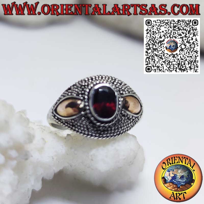Silver ring with oval garnet and 14-karat gold plates on the sides