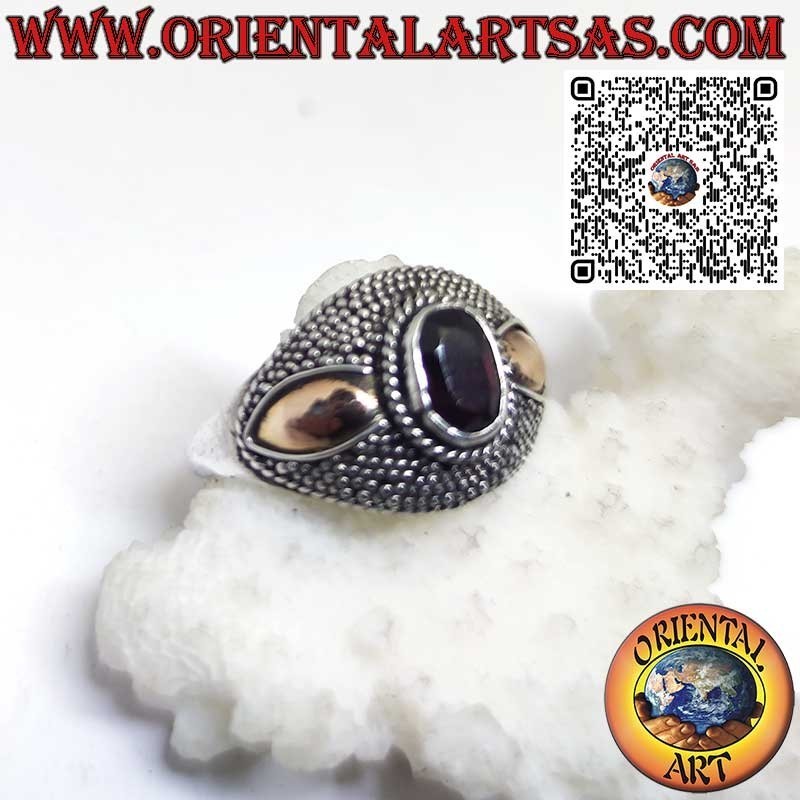 Silver ring with oval garnet and 14-karat gold plates on the sides