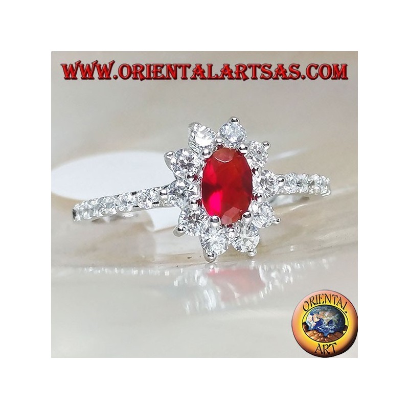 Silver ring with small oval garnet set surrounded by cubic zirconia and row on the sides