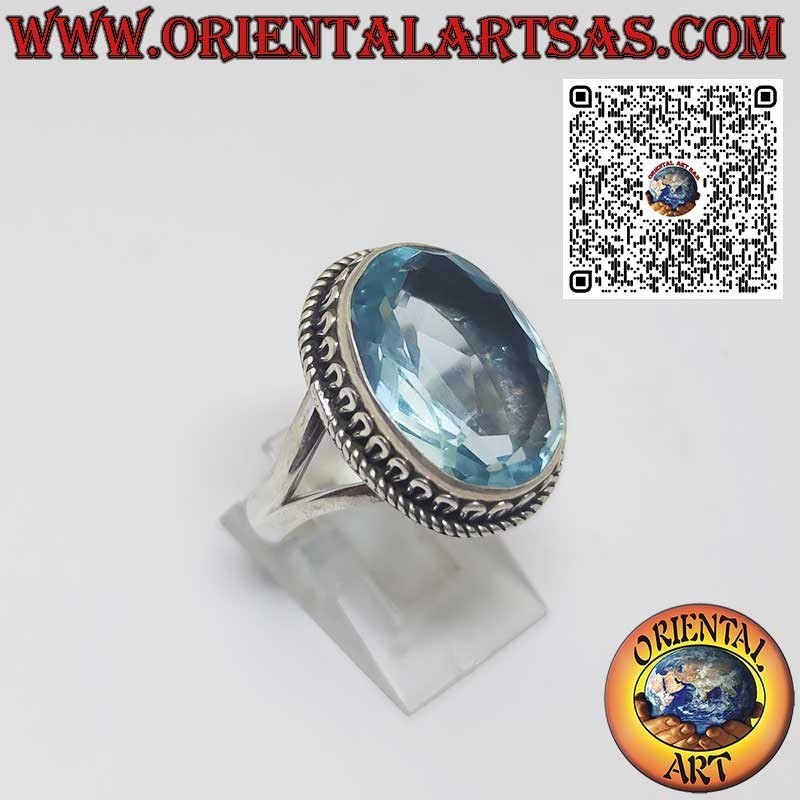 Sterling silver ring with oval blue topaz and wave-shaped setting