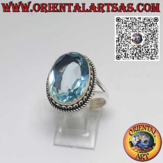 Sterling silver ring with oval blue topaz and wave-shaped setting